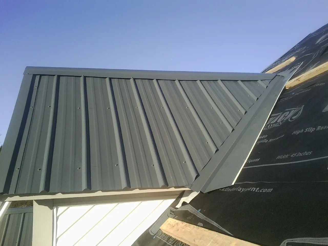 Gray metal roof panels going on over a garage gable in Gunlock