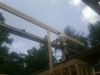 Carpenter setting a ridge beam over a new addition frame — Ice Dam Removal by Roofing Brothers in Gunlock