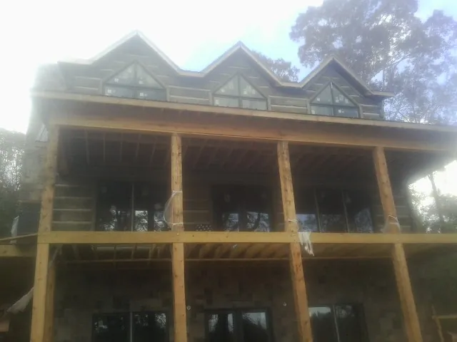 Dormers and porch framing on a large log home under construction — Roof Coating work by our crew in Gunlock
