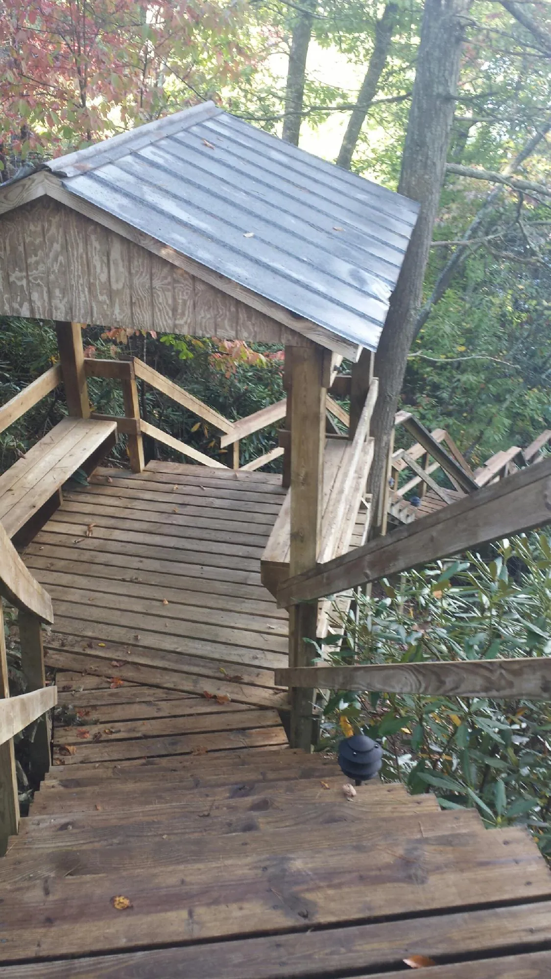 Metal roofed shelter over wooden steps on a wooded walkway — Skylight Repair & Installation work by our crew in Gunlock
