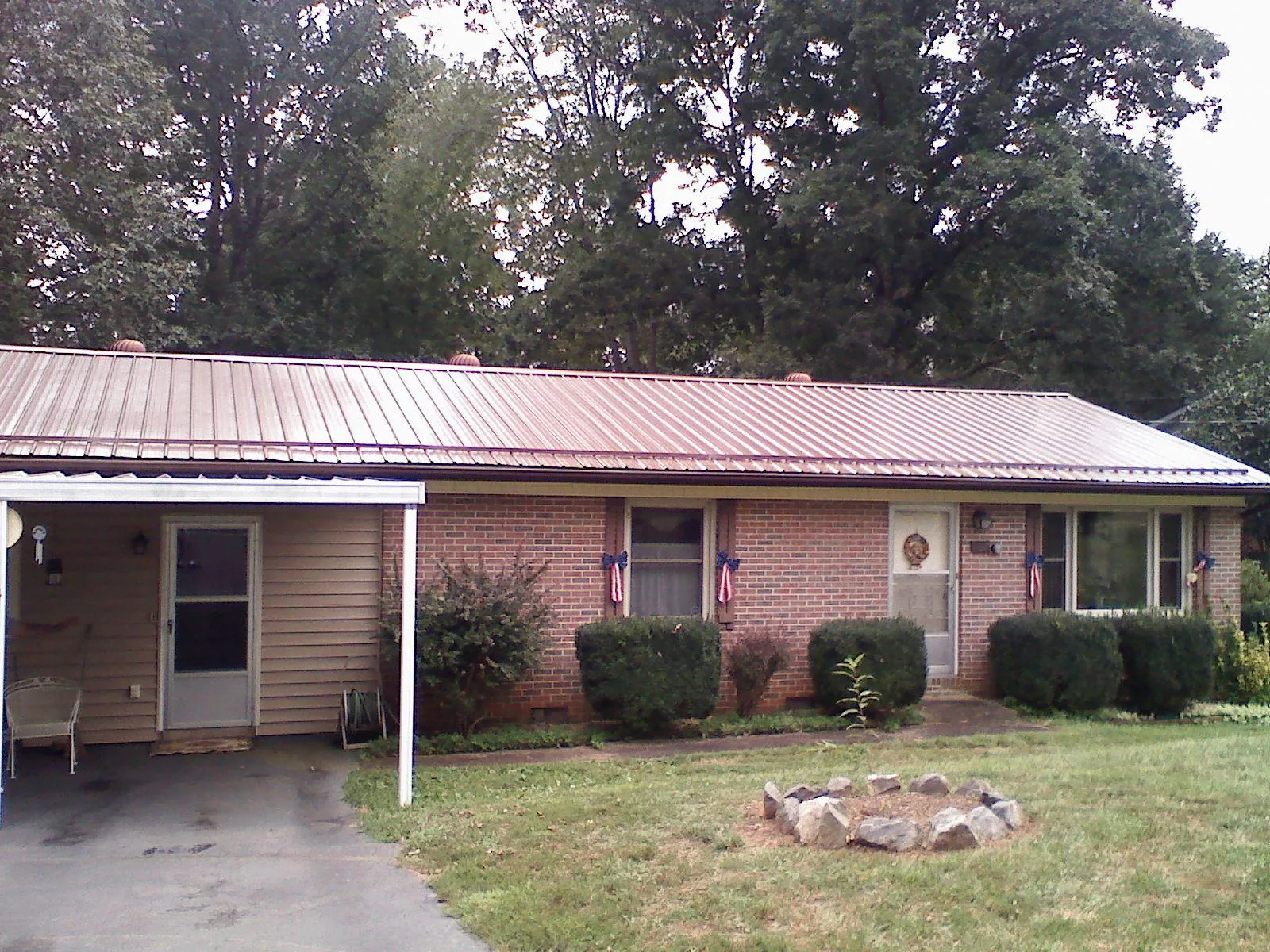 Bronze metal roof and carport on a brick ranch home — Roof Repair work by our crew in Gunlock